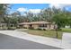 Charming single-story home featuring stone accents, mature trees and a well-manicured lawn at 19019 3Rd Ne St, Lutz, FL 33549
