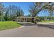 Charming single-story home featuring a covered carport, stone accents, mature trees and a well-manicured lawn at 19019 3Rd Ne St, Lutz, FL 33549