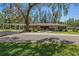 Charming home with stone accents, mature trees, and a covered carport at 19019 3Rd Ne St, Lutz, FL 33549
