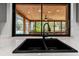 Modern kitchen sink with black faucet and large window overlooking the screened in patio and pool at 19019 3Rd Ne St, Lutz, FL 33549