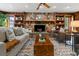 Inviting living room featuring a stone fireplace, wood shelving, and comfortable seating at 19019 3Rd Ne St, Lutz, FL 33549