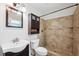 Bathroom featuring a tiled shower, dark cabinets, and modern fixtures at 2608 W Fletcher Ave, Tampa, FL 33618