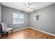 Comfortable bedroom featuring sleek hardwood floors, textured walls, and a ceiling fan at 2608 W Fletcher Ave, Tampa, FL 33618
