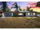 Charming single-story home with a palm tree and a two-car garage at sunset at 2608 W Fletcher Ave, Tampa, FL 33618