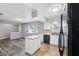Bright kitchen featuring white cabinets, an island, and modern black appliances at 2608 W Fletcher Ave, Tampa, FL 33618