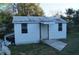 Exterior view of outbuilding featuring white siding, ramp entrance, and awning at 3421 E Powhatan Ave, Tampa, FL 33610