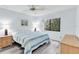 Bedroom with blue walls, ceiling fan, and large window providing natural light at 3590 Magnolia Ridge Cir # 1103-C, Palm Harbor, FL 34684