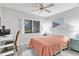 Comfortable bedroom with a ceiling fan, desk, and large window overlooking the exterior at 3590 Magnolia Ridge Cir # 1103-C, Palm Harbor, FL 34684