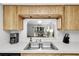 Kitchen with pass-through to the living room, stainless steel sink, and wood cabinets at 3590 Magnolia Ridge Cir # 1103-C, Palm Harbor, FL 34684