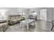 Open-concept living room with modern furniture, neutral colors, and hardwood-style floors at 3590 Magnolia Ridge Cir # 1103-C, Palm Harbor, FL 34684