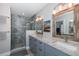 Bathroom featuring tiled shower, double vanity with granite countertops and decorative lighting at 3616 Harborview Ct, New Port Richey, FL 34652