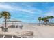 Picturesque beach scene featuring a covered picnic area, artistic mural, palm trees, and tranquil ocean waters at 3616 Harborview Ct, New Port Richey, FL 34652