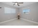 Bright bedroom with neutral walls, ceiling fan, and two windows with white blinds at 3616 Harborview Ct, New Port Richey, FL 34652