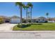 Beautiful home featuring a green lawn, mature palm trees, and a paved driveway leading to the attached garage at 3616 Harborview Ct, New Port Richey, FL 34652