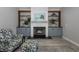 Cozy living room with fireplace, built-in shelves, and comfortable patterned armchair and ottoman at 3616 Harborview Ct, New Port Richey, FL 34652
