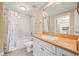 Bathroom with white tiled shower and tub, a white vanity, and orange countertops at 4516 Seagull Dr # 408, New Port Richey, FL 34652