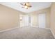 This bedroom features neutral walls, carpet, and a ceiling fan, with a closet and doorways visible at 4516 Seagull Dr # 408, New Port Richey, FL 34652