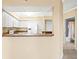 Kitchen with a passthrough and white appliances and cabinets open to other areas of the home at 4516 Seagull Dr # 408, New Port Richey, FL 34652