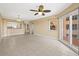 Spacious living room with a tile floor, modern ceiling fan, and access to the kitchen and a balcony at 4516 Seagull Dr # 408, New Port Richey, FL 34652