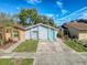 Charming single-Gathering home with a light blue exterior, a well-manicured lawn, and a concrete driveway at 4817 Glenaire Ct, Tampa, FL 33624