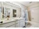 Bathroom featuring a double sink vanity, large mirror and tub with shower at 6518 Remus Dr, New Port Richey, FL 34653