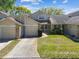 Charming townhome with a two-car garage, manicured lawn, and lush landscaping at 6518 Remus Dr, New Port Richey, FL 34653