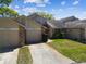 Charming townhome with a two-car garage, manicured lawn, and lush landscaping at 6518 Remus Dr, New Port Richey, FL 34653