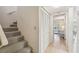 Hallway with carpeted staircase and closet leading into an interior living area with natural light at 6518 Remus Dr, New Port Richey, FL 34653