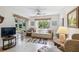 Comfortable living room with access to the outdoors, featuring a ceiling fan and neutral decor at 6518 Remus Dr, New Port Richey, FL 34653