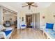 Bright sunroom featuring wood floors, ceiling fan, and comfortable wicker furniture with blue cushions overlooking the interior at 6518 Remus Dr, New Port Richey, FL 34653