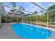 Screened-in pool with a bright blue interior, set in a backyard surrounded by mature trees at 7083 Devlin St, Weeki Wachee, FL 34613