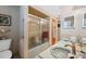 A clean bathroom featuring a shower/tub combo with sliding doors and built-in shelving at 7514 Bergamot Dr, Port Richey, FL 34668