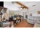 Living room with hardwood floors, beamed ceiling, and access to the kitchen and backyard at 7514 Bergamot Dr, Port Richey, FL 34668