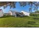 Manicured backyard featuring a screened-in lanai, an expansive lawn, and trimmed perimeter shrubs at 9131 Rhett Ln, Weeki Wachee, FL 34613