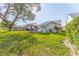 Backyard featuring a screened-in lanai, mature trees, and manicured landscaping at 9131 Rhett Ln, Weeki Wachee, FL 34613