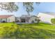 Landscaped backyard featuring a screened-in lanai with an expansive lawn at 9131 Rhett Ln, Weeki Wachee, FL 34613