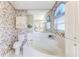 Elegant bathroom with an inviting corner tub, charming floral wallpaper, and abundant natural light streaming in at 9131 Rhett Ln, Weeki Wachee, FL 34613