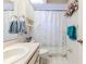 Traditional bathroom with a vanity, toilet, and shower with a lace curtain, decorated with floral accents at 9131 Rhett Ln, Weeki Wachee, FL 34613