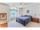 Bright bedroom with neutral carpet, a ceiling fan, and a bench seat beneath a large arched window at 9131 Rhett Ln, Weeki Wachee, FL 34613