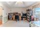 Spacious bedroom with a desk, shelving, and a queen bed beneath a tray ceiling with fan at 9131 Rhett Ln, Weeki Wachee, FL 34613