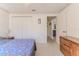 Cozy bedroom with light walls, white trim, and carpeted floors, with an open doorway leading to the hallway at 9131 Rhett Ln, Weeki Wachee, FL 34613