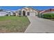 View of the exterior of a one-story home with manicured landscaping and a two-car garage at 9131 Rhett Ln, Weeki Wachee, FL 34613