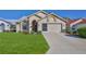 Charming single-story home with a well-manicured lawn, a two-car garage, and an arched entryway at 9131 Rhett Ln, Weeki Wachee, FL 34613