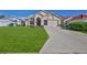 Charming single-story home with a well-manicured lawn, a two-car garage, and an arched entryway at 9131 Rhett Ln, Weeki Wachee, FL 34613