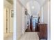 Hallway with tile flooring leading to wood flooring, featuring a decorative cabinet at 9131 Rhett Ln, Weeki Wachee, FL 34613