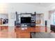 Comfortable living room showcasing hardwood floors, a large entertainment center, and open access to other rooms at 9131 Rhett Ln, Weeki Wachee, FL 34613