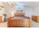 Main bedroom with an exercise bike and a large bed, dresser, and windows above the bed at 9131 Rhett Ln, Weeki Wachee, FL 34613