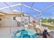 The screened-in outdoor area features a rock-lined hot tub with an installed stainless steel handrail at 9131 Rhett Ln, Weeki Wachee, FL 34613