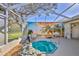 Screened-in outdoor area featuring a rock-lined hot tub and a tropical-themed privacy screen at 9131 Rhett Ln, Weeki Wachee, FL 34613