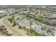 An aerial view shows a community with mature trees, landscaping, water feature, and a nearby golf course at 9144 Bassett Ln, New Port Richey, FL 34655